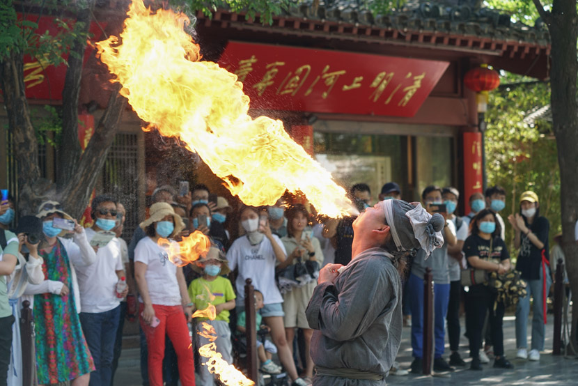A folk performer spits fire at Millennium City Park in Kaifeng, Henan province, May 22, 2020. Ma Jian/People Visual