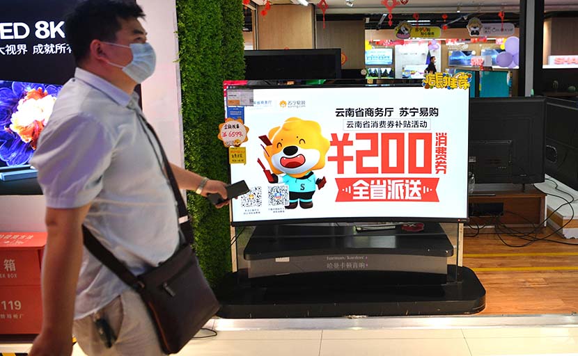 A poster promoting consumption coupons released by provincial authorities is displayed at a shopping mall in Kunming, Yunnan province, April 11, 2020. Liu Ranyang/CNS/People Visual