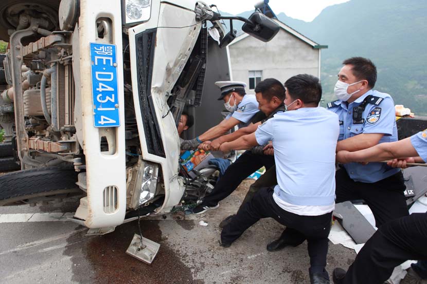 Police officers help rescue a man from the smashed cab of a truck after a traffic accident in Yichang, Hubei province, May 28, 2020. Wu Lingjian/People Visual