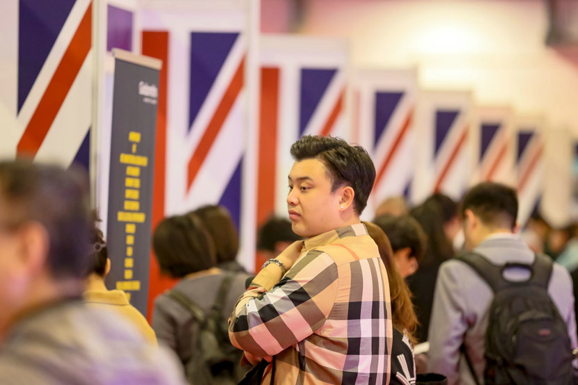 A man browses the booths at an educational fair in Beijing, Oct. 19, 2019. People Visual