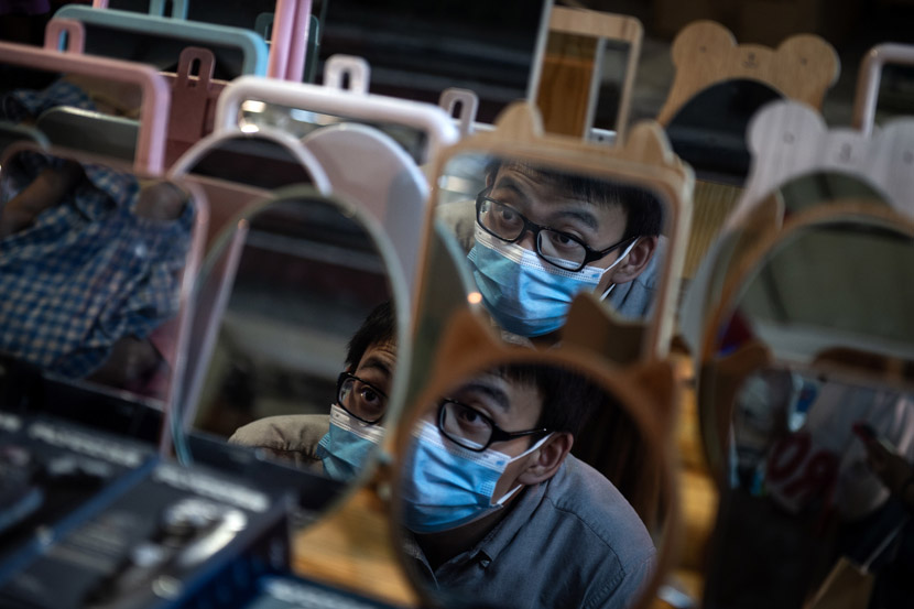 A shopper checks his reflection at a night market in Wuhan, Hubei province, June 3, 2020. Don McCurren/IC