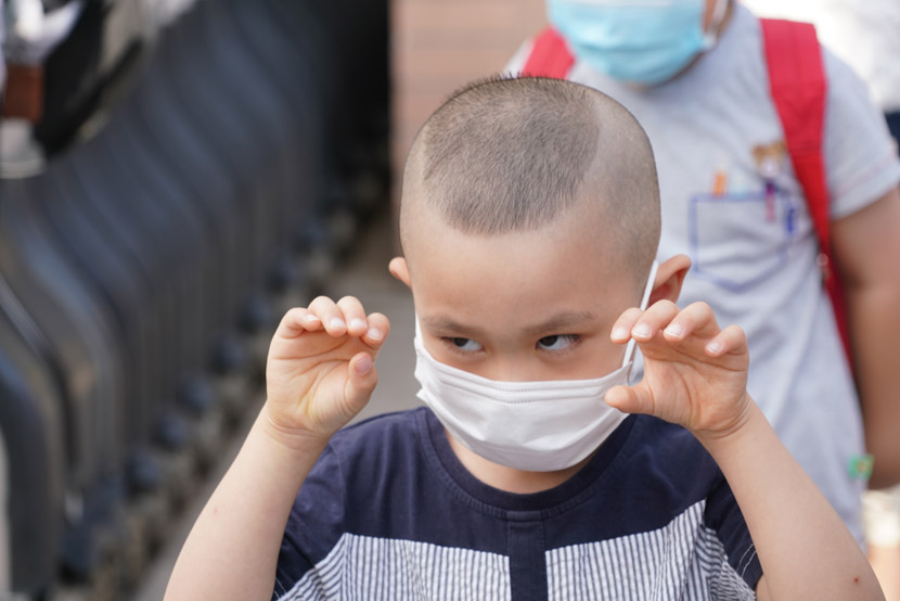 A boy makes a face at the gate of a kindergarten in Shanghai, June 2, 2020. The city’s kindergartners as well as first through third graders returned to school this week. Wang Xiaofei/People Visual