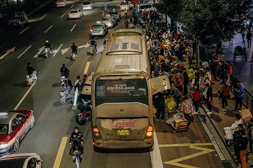 People wait to return to central Hubei province at a bus stop near Datang Village’s metro station, Guangzhou, Guangdong province, April 26, 2020. Wu Huiyuan/Sixth Tone