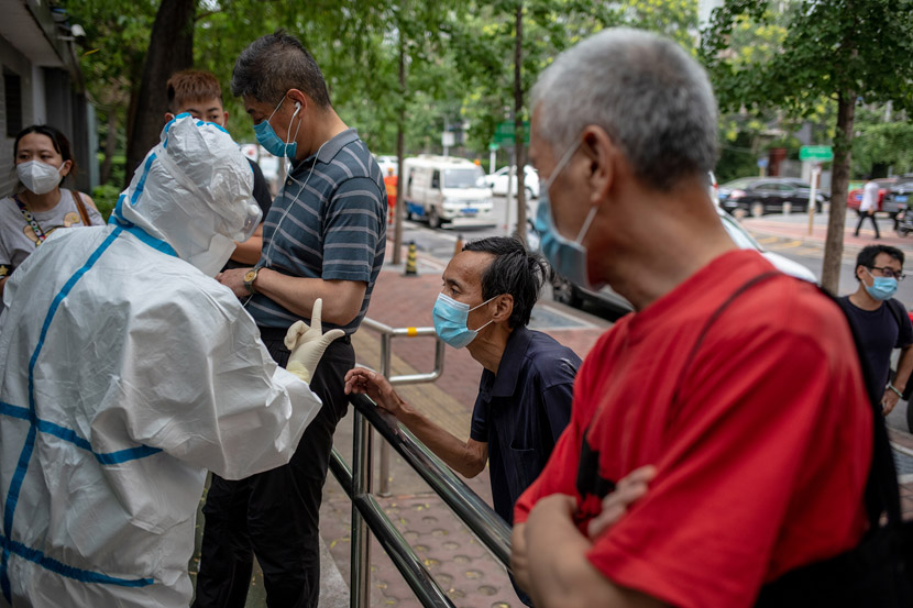 A nurse explains the appointment system to patients outside a fever clinic in Beijing Puren Hospital in Beijing, June 17, 2020. Li Junhui/China Youth Daily/People Visual