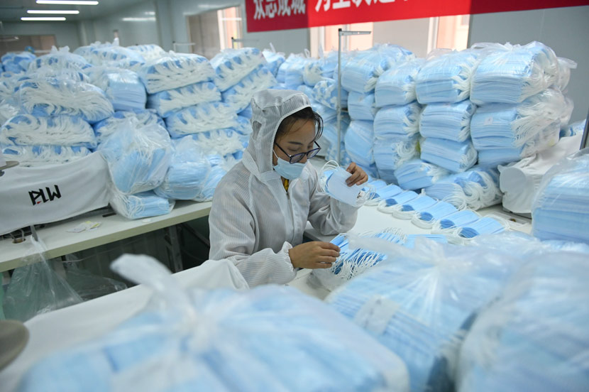 A worker sorts face masks at a factory in Shenyang, Liaoning province, May 16, 2020. Yu Haiyang/CNS/People Visual