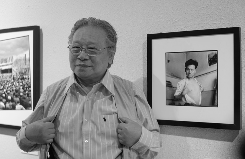 Li Zhensheng poses for a photo in front of a self-portrait he took in 1966 during an exhibition in Jinan, Shandong province, Oct. 12, 2012. Wu Hong/People Visual