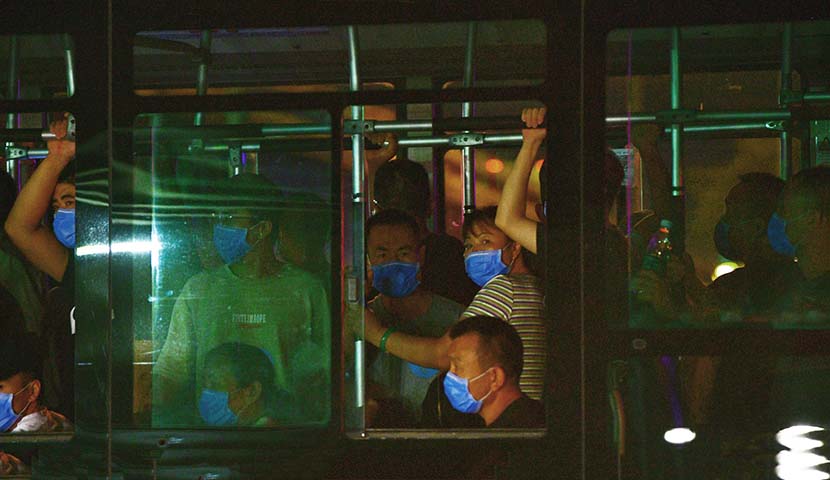 Workers at the Xinfadi market are evacuated by bus in Beijing, June 13, 2020. On that day, officials reported that 46 people connected to the Xinfadi market — the largest farmers market in China’s capital — had tested positive for the coronavirus. Fu Ding/Beijing Youth Daily/People Visual