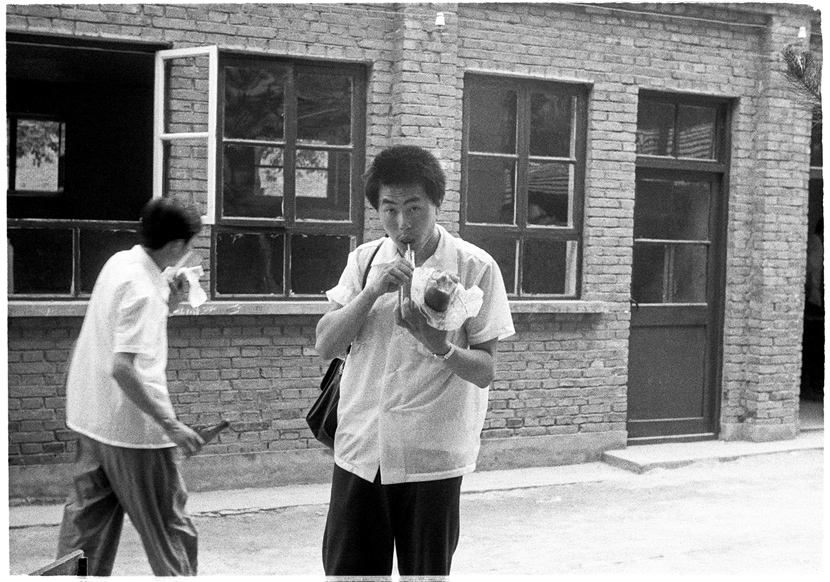 Students grab a snack outside the exam venue, Beijing, 1979. Ren Shulin for Sixth Tone