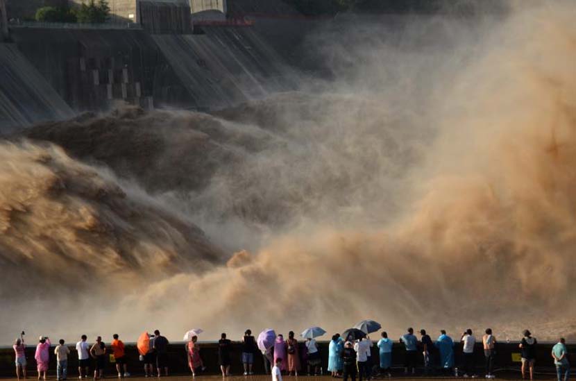 Tourists watch floods surge from the Xiaolangdi Dam in Jiyuan, Henan province, July 6, 2020. Lü Jianping/People Visual