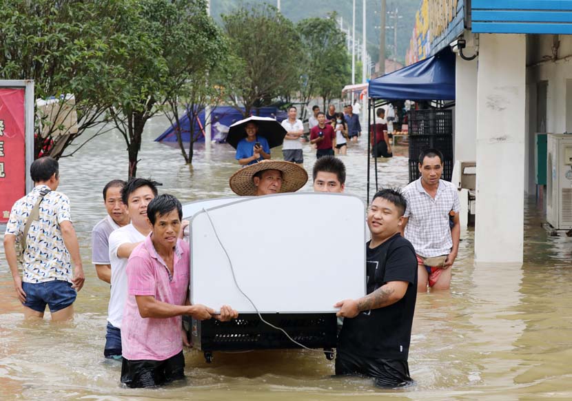 People move electronic appliances out of a flooded area in Liuzhou, Guangxi Zhuang Autonomous Region, July 11, 2020. People Visual