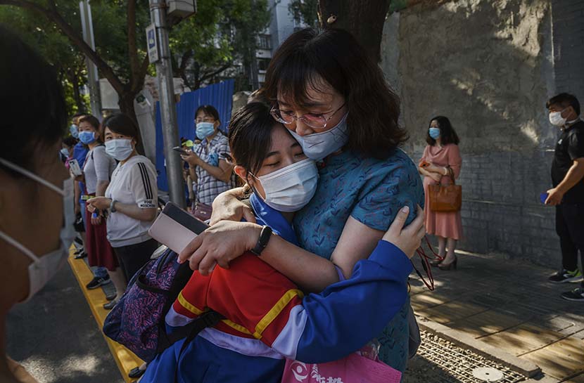 A mother and a daughter hug each other before the gaokao college-entrance exam starts at a high school in Beijing, July 7, 2020. People Visual