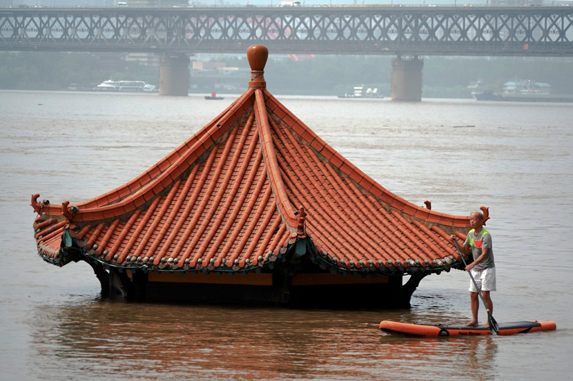 A man on a raft paddles by a submerged building on a branch of the Yangtze River in Wuhan, Hubei province, July 9, 2020. People Visual