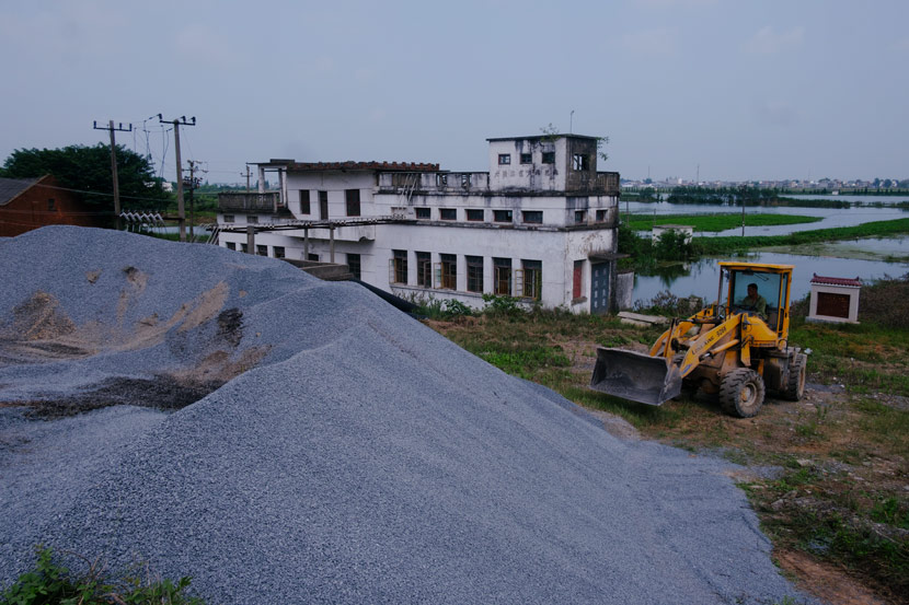 Workers transfer sand and stone for flood control in Jiangzhou Town, Jiangxi province, July 14, 2020. Wu Huiyuan/Sixth Tone