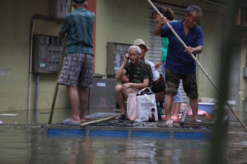 A man calls family members to tell them he’s safe as rescuers transfer him from a flooded area in Chaohu, Anhui province, July 23, 2020. People Visual