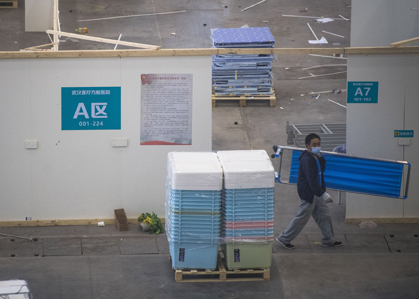 A worker moves medical equipment from a convention center that had been converted into a temporary shelter hospital, or “fangcang,” in Wuhan, Hubei province, July 29, 2020. Xiao Yijiu/Xinhua
