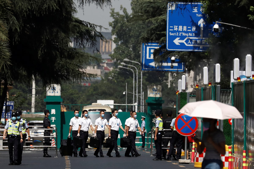 Security personnel walk in front of the now-closed U.S. Consulate in Chengdu, Sichuan province, July 27, 2020. Thomas Peter/People Visual