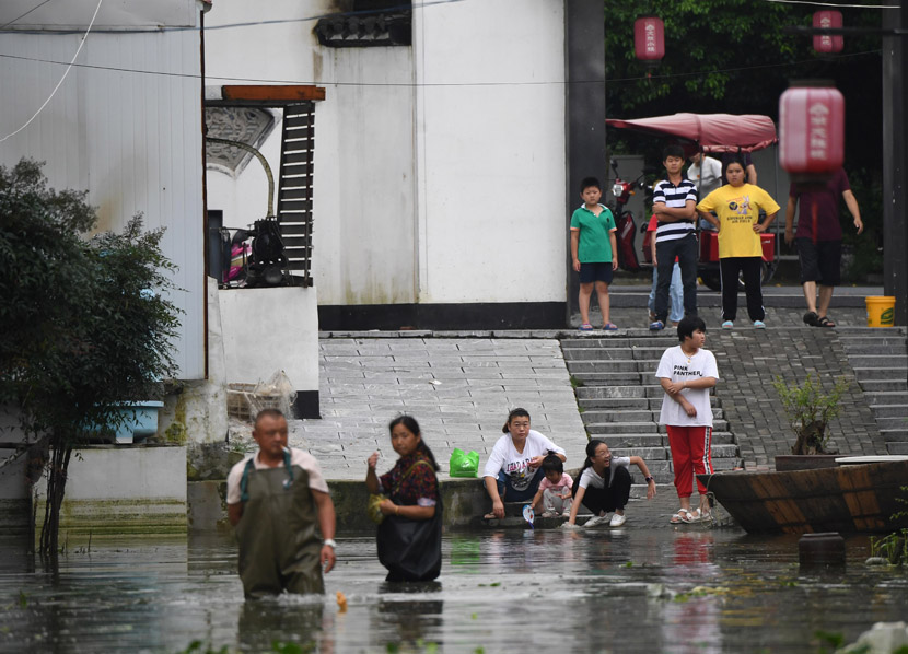 People wade through floodwaters in the town of Zhongmiao, Anhui province, July 28, 2020. Cui Nan/CNS/People Visual
