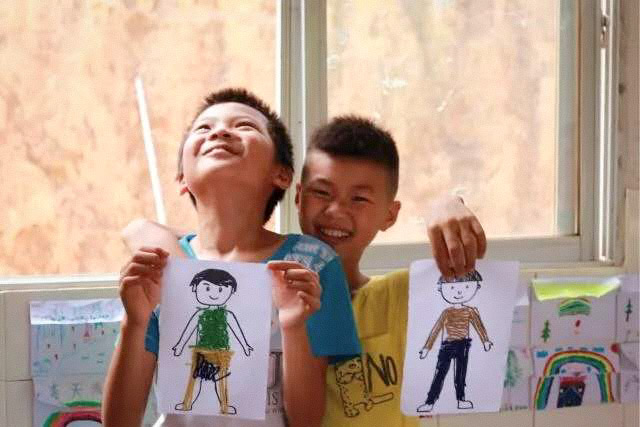 Boys display their drawings during a sex education class at a rural primary school, 2017. Courtesy of You&Me