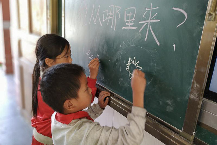 Children draw sperm and eggs on the blackboard during a sex education class at a rural primary school. Courtesy of You&Me