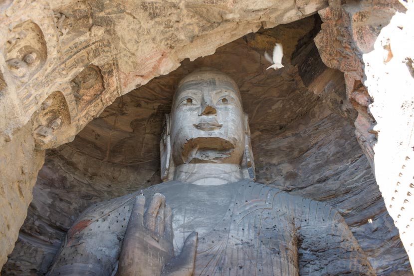 Across the highway from the Jinhuagong coal mine, Buddha statues at the Yungang Grottoes witness the changes in Datong, Shanxi province, Nov. 7, 2016. Zhou Pinglang/Sixth Tone