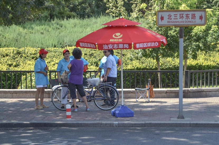 ‘Chaoyang Masses’ volunteers converse near a guard station in Chaoyang District, Beijing, Aug. 31, 2015. Li Gang/IC