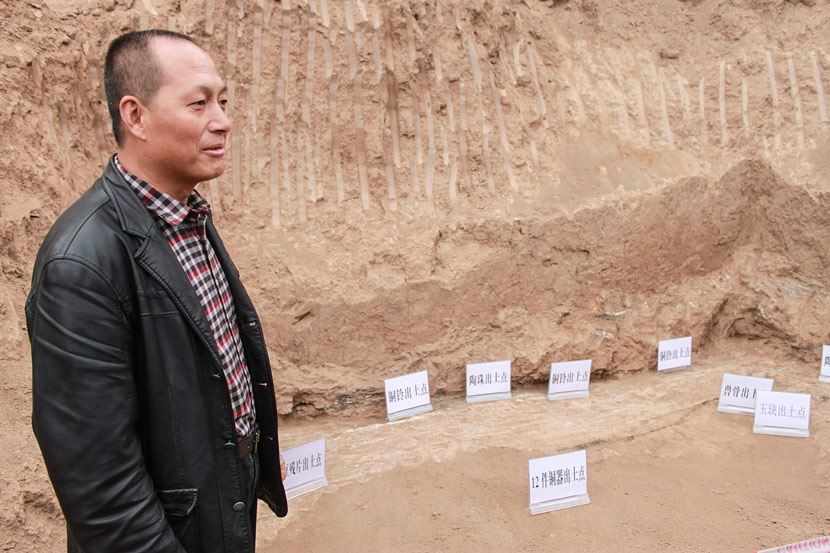Wei Bingxiang stands by the artifact excavation site in his backyard in Weijiaya Village, Baoji, Shaanxi province, Oct. 22, 2014. Zhou Jinzhu/VCG