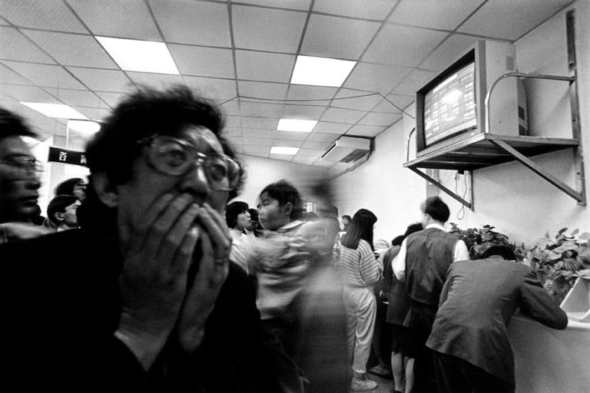 A man anxiously watches a monitor at a stock exchange in Shenzhen, Guangdong province, 1992. From Daken Art Center