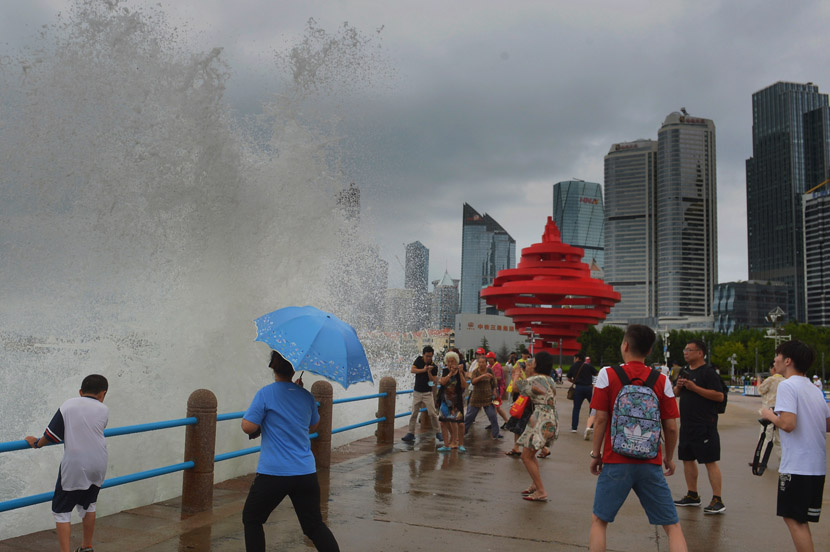 Pedestrians witness a large wave caused by Typhoon Bavi in Qingdao, Shandong province, Aug. 26, 2020. Wang Haibin/People Visual