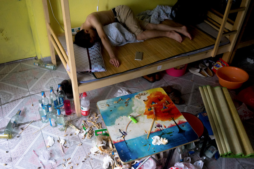 A young migrant worker passes out in his bed after drinking all night in Shenzhen, Guangdong province, May 10, 2017. Chen Jin for Sixth Tone