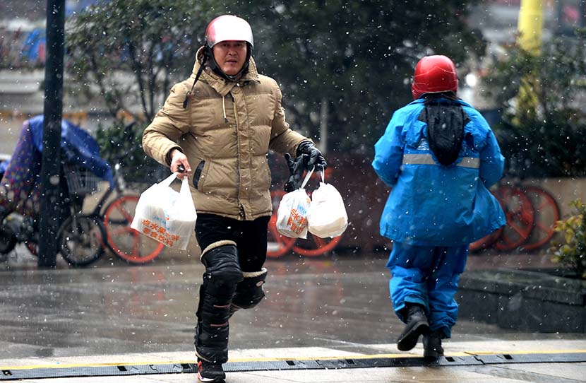 A food-delivery worker runs to complete an order in Jinan, Shandong province, Dec. 24, 2017. People Visual