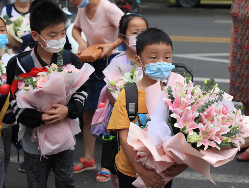 Primary school children hold flower bouquets for their teachers to mark Chinese Teachers’ Day in Nanjing, Jiangsu province, Sept. 10, 2020. People Visual
