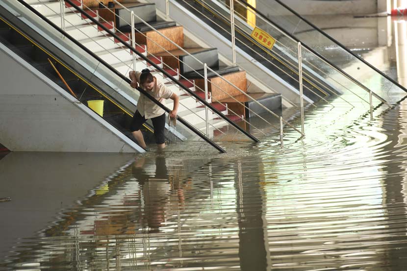 A cleaner washes an escalator in Chongqing, Aug. 21, 2020. Chen Chao/CNS/People Visual