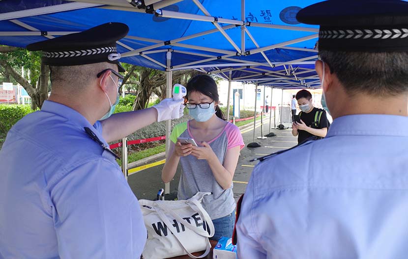 A student gets her temperature checked entering the campus of Jinan University in Guangzhou, Guangdong province, May 11, 2020. People Visual