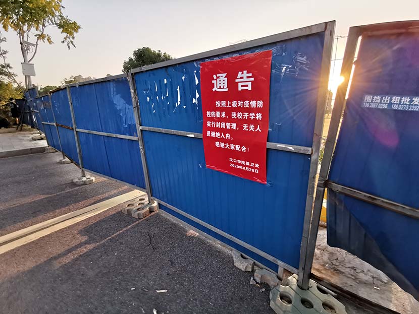 A poster reading “no one can enter the campus” is displayed on a temporary barrier at a university in Wuhan, Hubei province, Sept. 4, 2020. People Visual