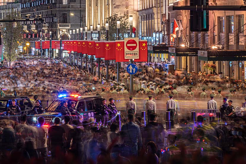 Police officers maintain order in the streets as tourists gather to watch a light show for the National Day holiday in Shanghai, Sept. 30, 2020. People Visual