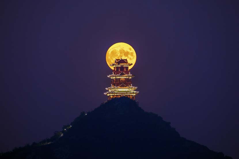 The moon is seen behind the Dingdu Pavilion on the evening of Mid-Autumn Festival, Beijing, Oct. 1, 2020. Wu Luping/People Visual