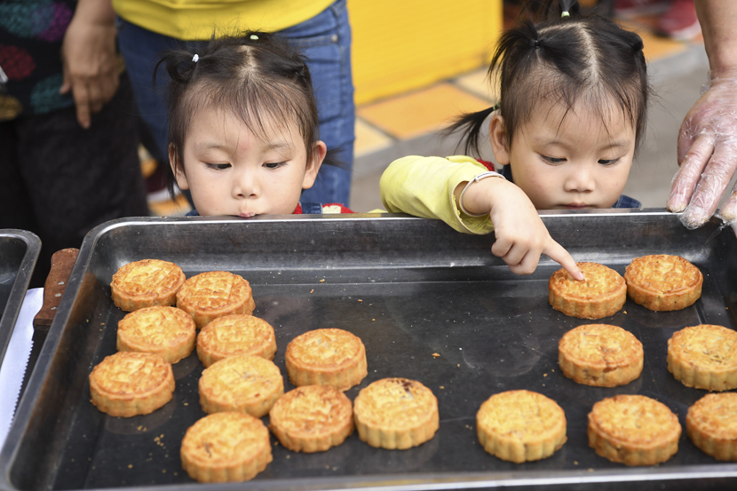 Twin girls pick out their favorite mooncakes ahead of the Mid-Autumn Festival in Chongqing, Sept. 26, 2020. Chen Chao/CNS/People Visual