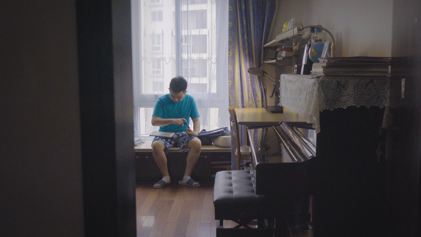 Cai Lechen plays with his iPad at home in Shanghai, September 2020. Zhu Jiaqi for Sixth Tone