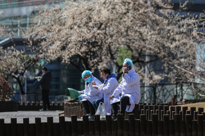 Doctors have lunch outside a hospital in Wuhan, Hubei province, Feb. 16, 2020. Chen Zhuo/Changjiang Daily/People Visual