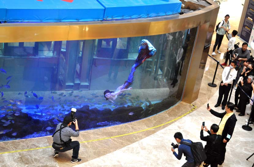 Photographers capture a “mermaid” in a shopping mall in Shanghai, Oct. 17, 2020. The shopping mall held its first mermaid competition, attracting more than 30 participants. People Visual