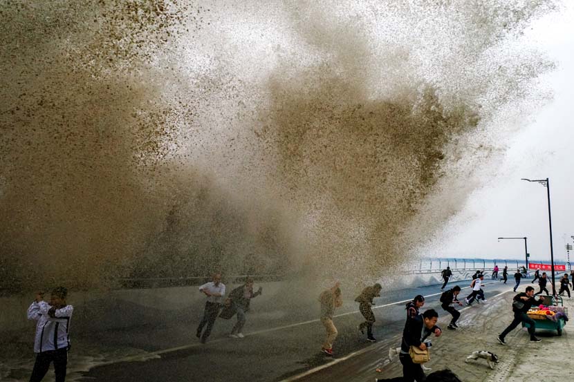 People flee from a huge wave along the Qiantang River, Oct. 18, 2020. People Visual