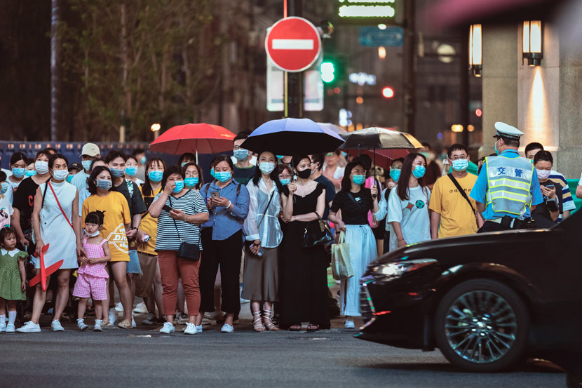 People wearing masks wait to cross the street in Shanghai, June 19, 2020. Jiang Zhenyao/People Visual