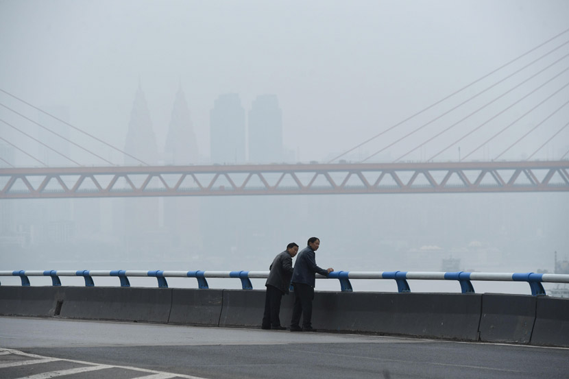 Two men stand on a bridge during a foggy day in Chongqing, Oct. 19, 2020. Chen Chao/CNS/People Visual