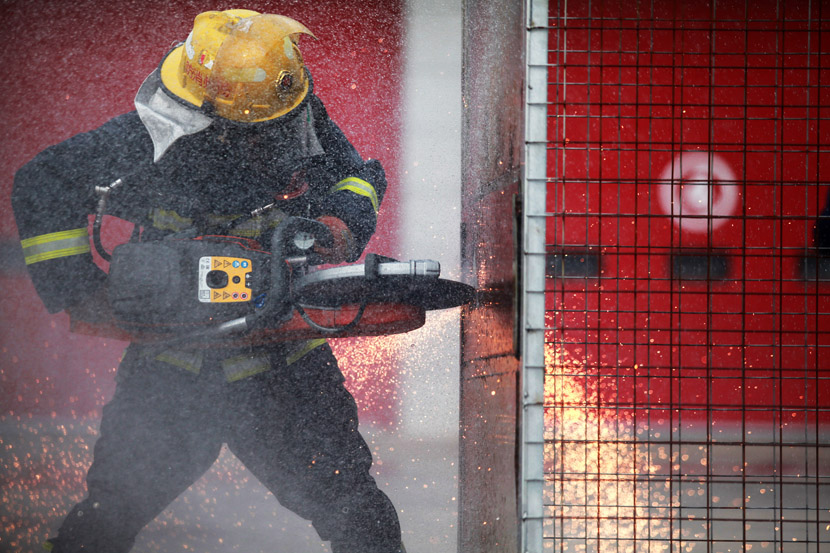 A firefighter cuts a steel plate during a drill in Yangzhou, Jiangsu province, Oct. 21, 2020. Meng Delong/People Visual