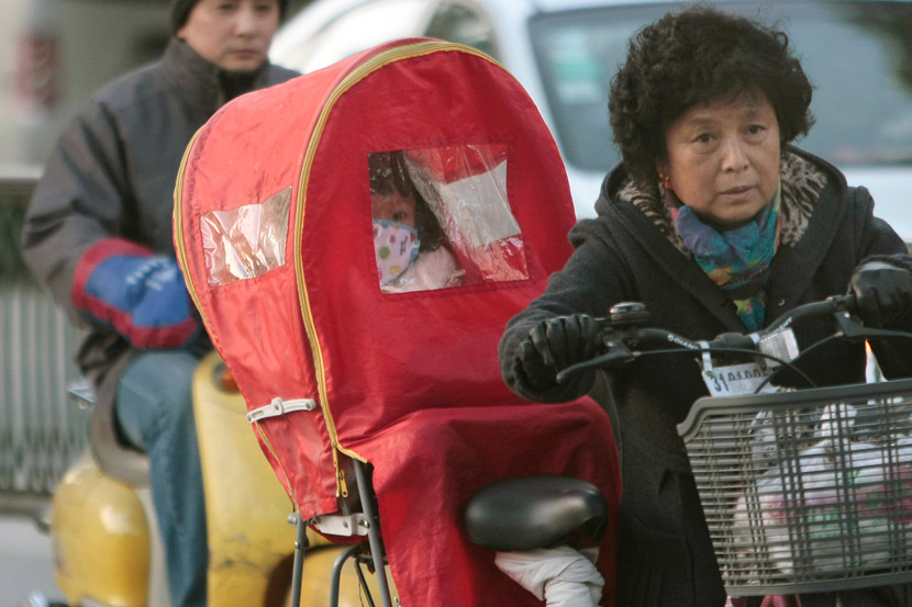 A woman takes her grandchild home by bike in Nanjing, Jiangsu province, Dec. 7, 2010. An Xin/People Visual