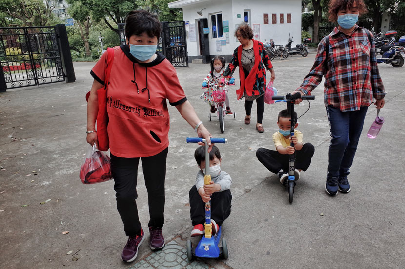 Seniors take their grandchildren home after a visit to a park in Shanghai, May 14, 2020. People Visual