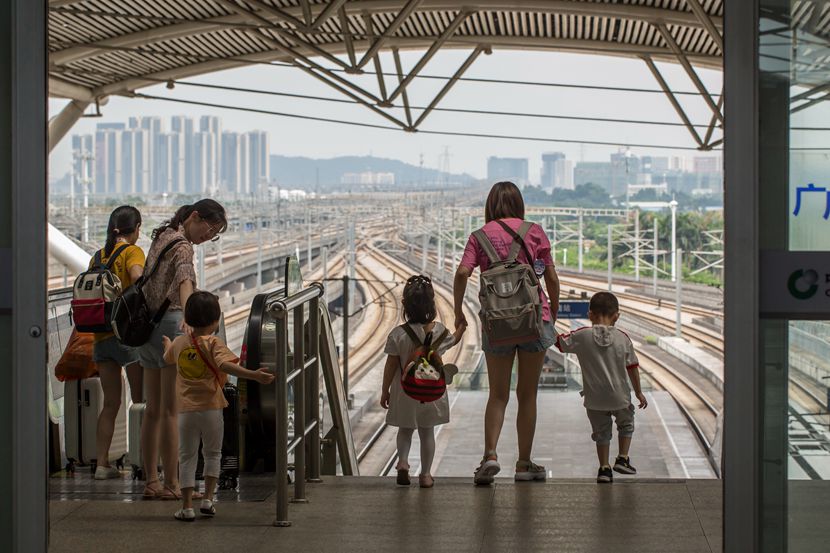 Parents and their children get ready to board a train at a railway station in Guangzhou, Guangdong province, July 1, 2019. Liang Weipei/Southern Metropolis Daily/People Visual