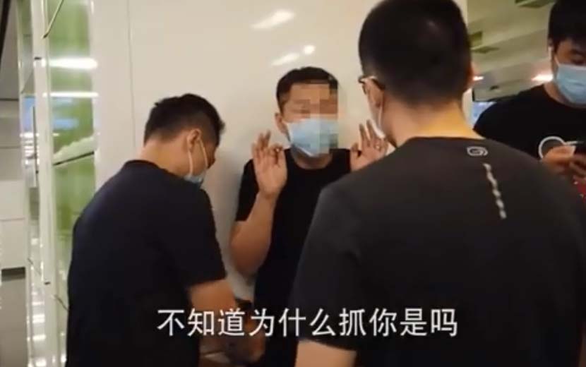 A video screenshot of a suspected subway groper being apprehended by police. From @侠客岛 on Weibo