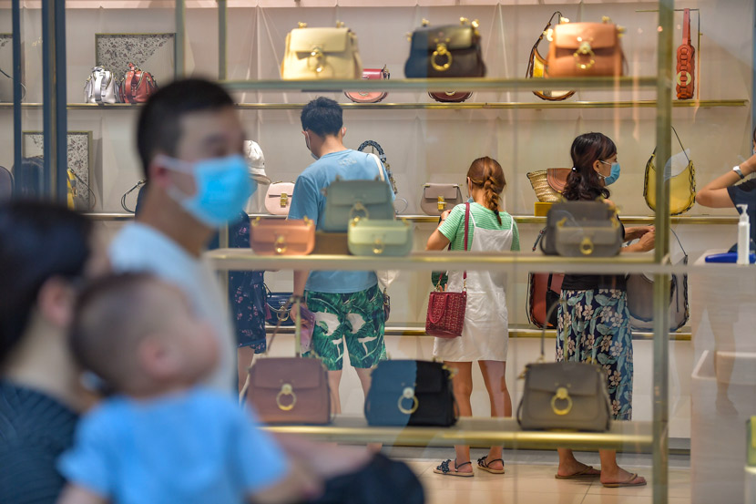 People look at handbags at a duty-free shop in Sanya, Hainan province, Oct. 2, 2020. Luo Yunfei/CNS/People Visual