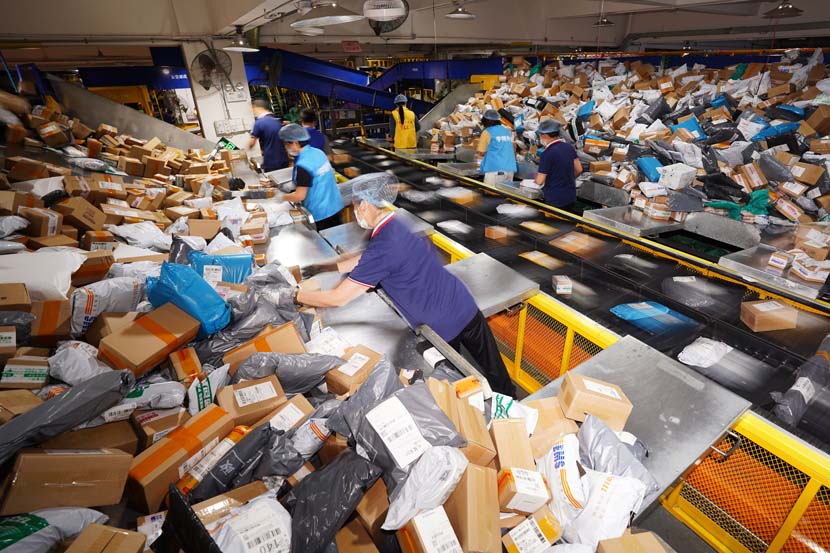 Workers sort packages at a delivery center on “Double Eleven,” China’s largest e-commerce shopping day, in Dongguan, Guangdong province, Nov. 11, 2020. People Visual
